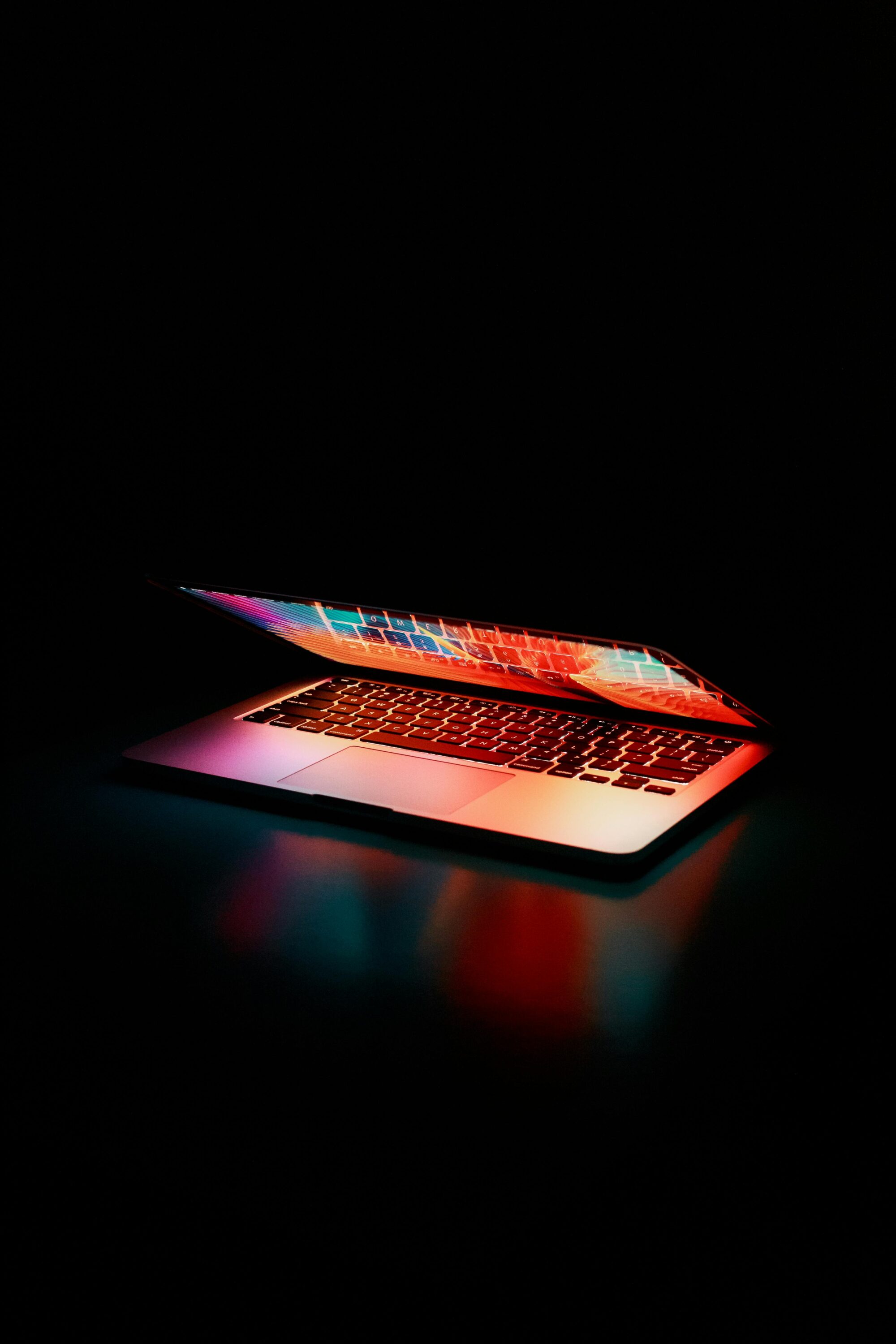 image of a macbook half way shut with a dark background